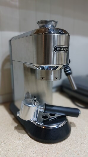 A De'Longhi espresso machine with a metallic finish, a digital display, and a black handle.