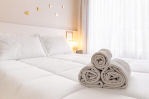 A neatly made bed with white bedding and rolled towels on the side. - Av0310 Studio Avanhandava (São Paulo)