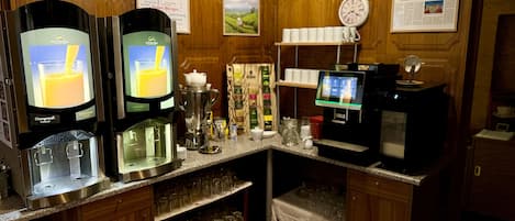 A self-service beverage station with multiple dispensers, a coffee machine, and a digital menu display.