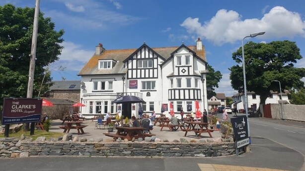 The Clarke's Hotel with outdoor seating and a stone wall. - The Clarkes Hotel (Barrow-in-Furness)