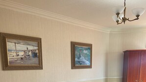 A hotel room with two beds, a wooden headboard, a nightstand with a lamp, and a wardrobe. - The Clarkes Hotel (Barrow-in-Furness)