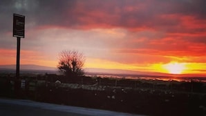 A sunset over a rural landscape with a signboard in the foreground. - The Clarkes Hotel (Barrow-in-Furness)