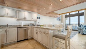 A spacious kitchen with wooden ceiling, large windows, and a view of the ocean. - Exquisite 2 Story Penthouse with Spectacular Views of the Ocean and the Bay (Ocean City)