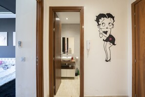 A hotel bathroom with a wooden door, a sink, and a mirror. - Chez Betty with rooftop Swimming pool (Casablanca)
