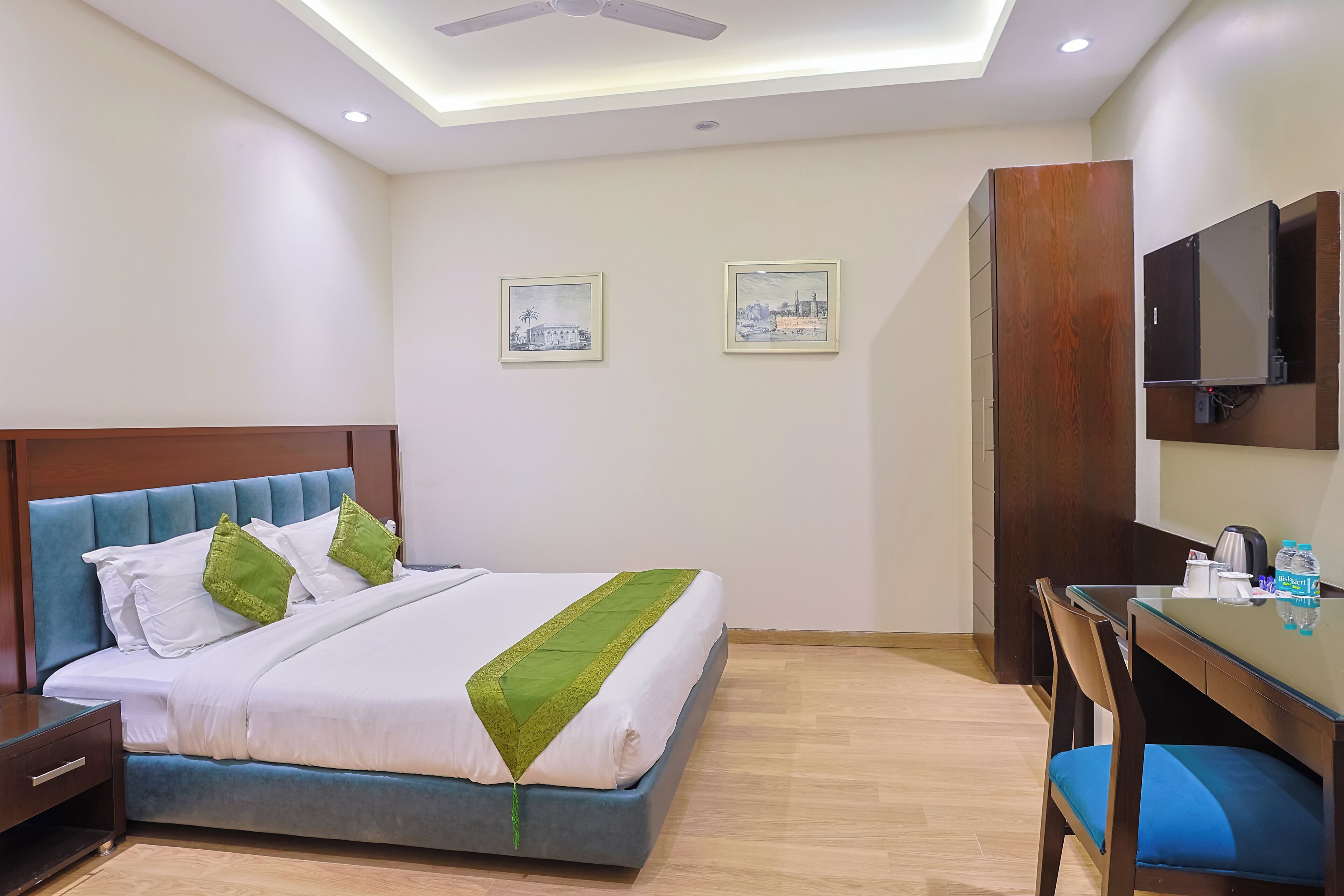 A hotel room with a bed, a desk, and a TV.