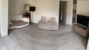 Une chambre moderne avec deux lits, un téléviseur à écran plat et un tableau au mur.