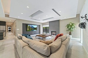 A modern living room with a sofa, a coffee table, and a fireplace. - South Miami Gem • Near Zoo, The Falls | Pool_BBQ (Cutler Bay)