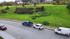A parking lot with three cars parked in a row. - Buena Ubicación 2 Dormitorios 2 Baños (Puerto Montt)