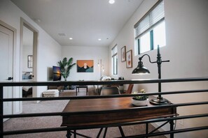 A modern interior with a wooden desk, a lamp, and a painting on the wall. - Serene Lake Getaway at Stunning Scandi Home (Coeur d'Alene)