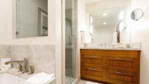 A modern bathroom with a marble sink, wooden vanity, and a glass shower enclosure. - Deluxe King Room Hotel Room by RedAwning (Park City)