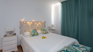 Una camera da letto con un letto, due comodini, una testiera decorativa e una finestra con tende.