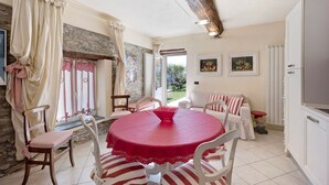 A dining area with a round table, chairs, a red tablecloth, and a view of the outdoors. - Holiday Home "Casa dei Tigli" with Mountain View, Garden & Wi-Fi (Ormea)