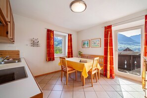 A dining area with a table, chairs, and a view of the outdoors.