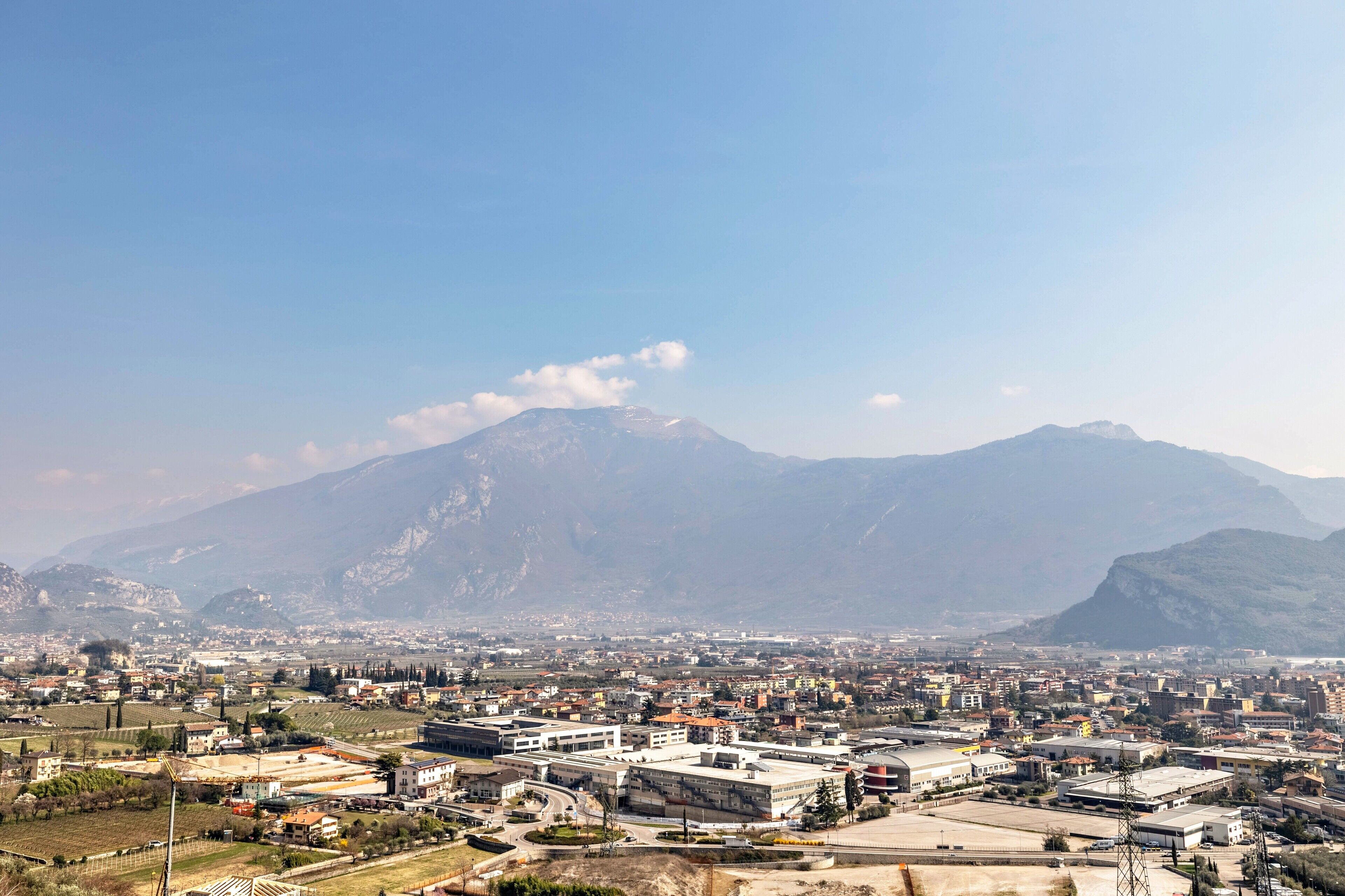 A cityscape with a mountain in the background, buildings, and a clear sky.