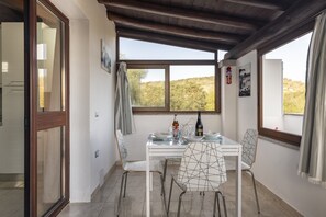 Un comedor con mesa, sillas y vistas al exterior.