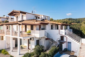 Un edificio de varios pisos con balcones, una escalera y una piscina.