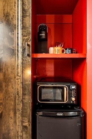 Un petit coin cuisine équipé d’une machine à café, d’un four à micro-ondes et d’un grille-pain.