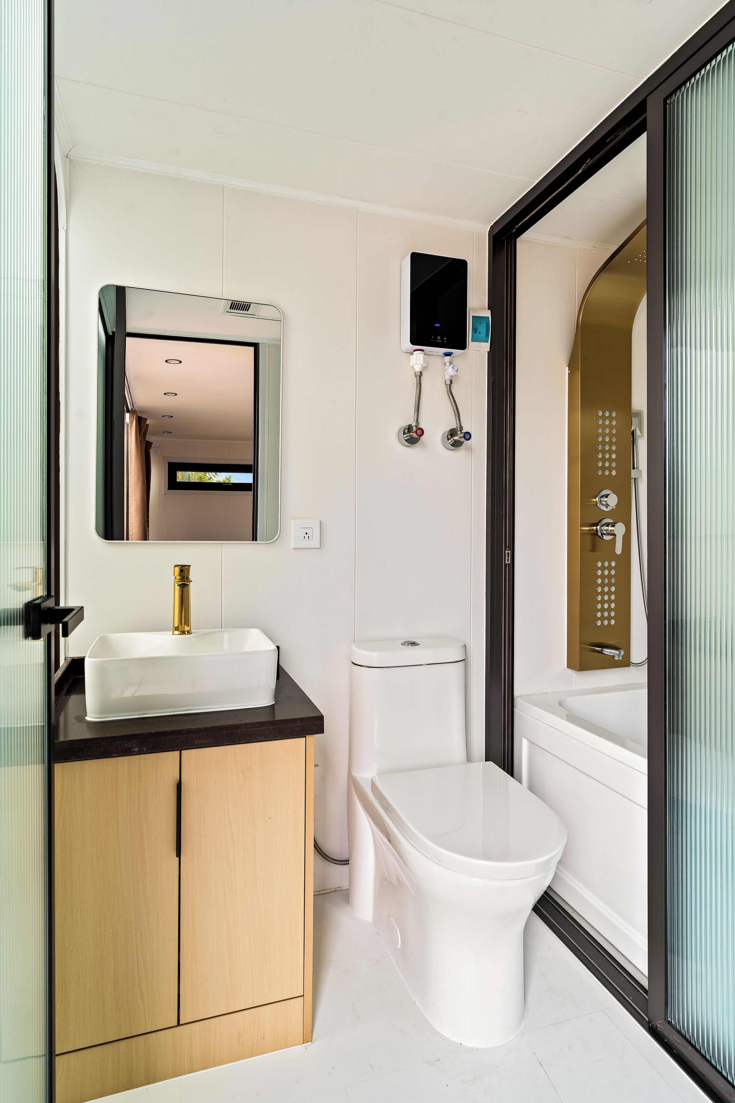 Une salle de bain moderne avec un lavabo blanc, des toilettes et un espace douche.