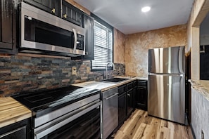 A modern kitchen with a stainless steel refrigerator, a microwave, and a dishwasher.