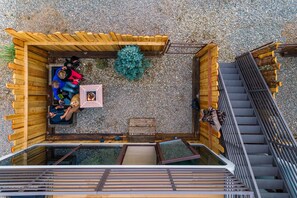 Une terrasse sur le toit avec une plateforme en bois, un espace salon et un escalier.