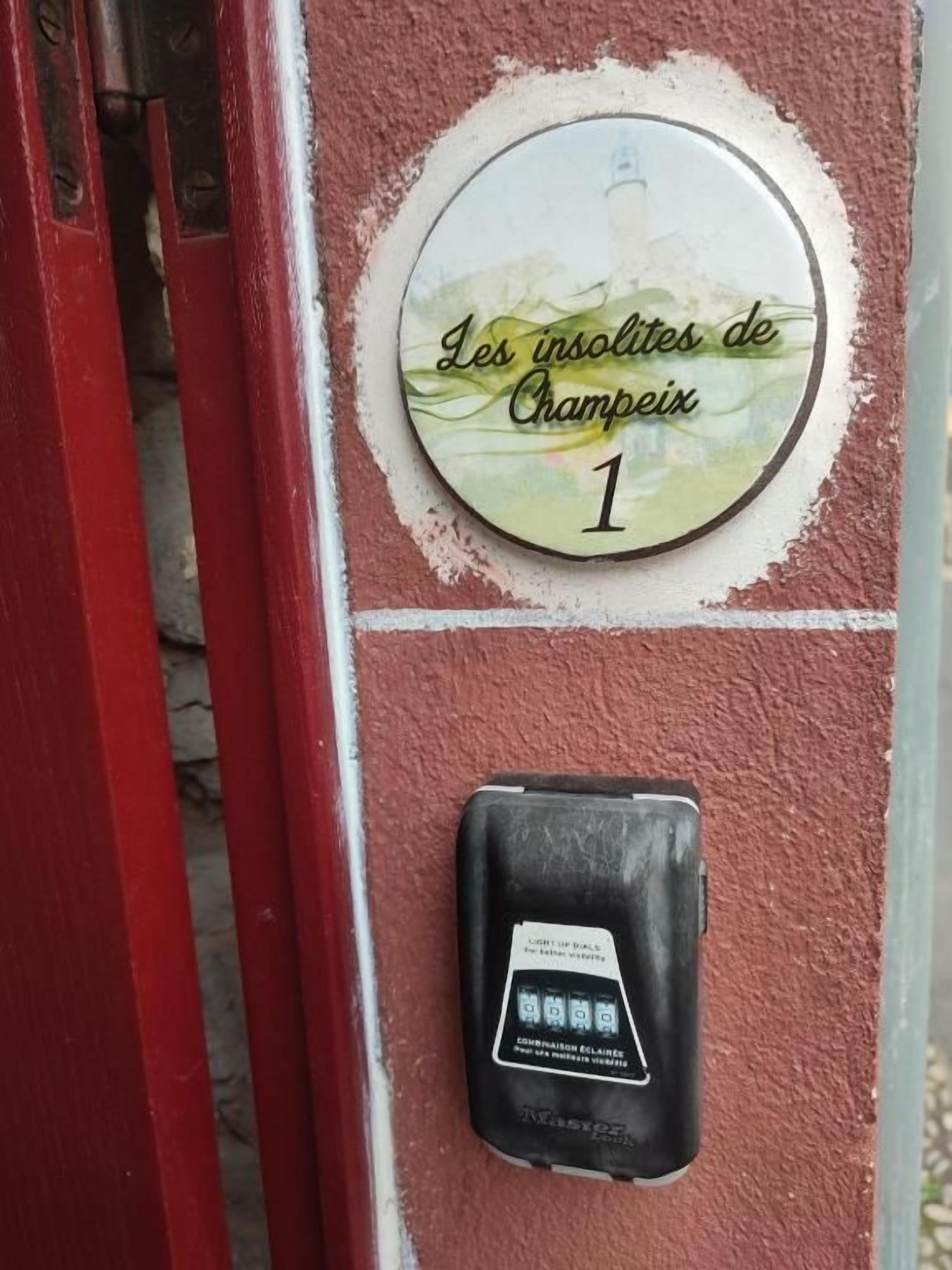 A door with a plaque reading 'Les insoles de Champenois 1' and a security device below it.