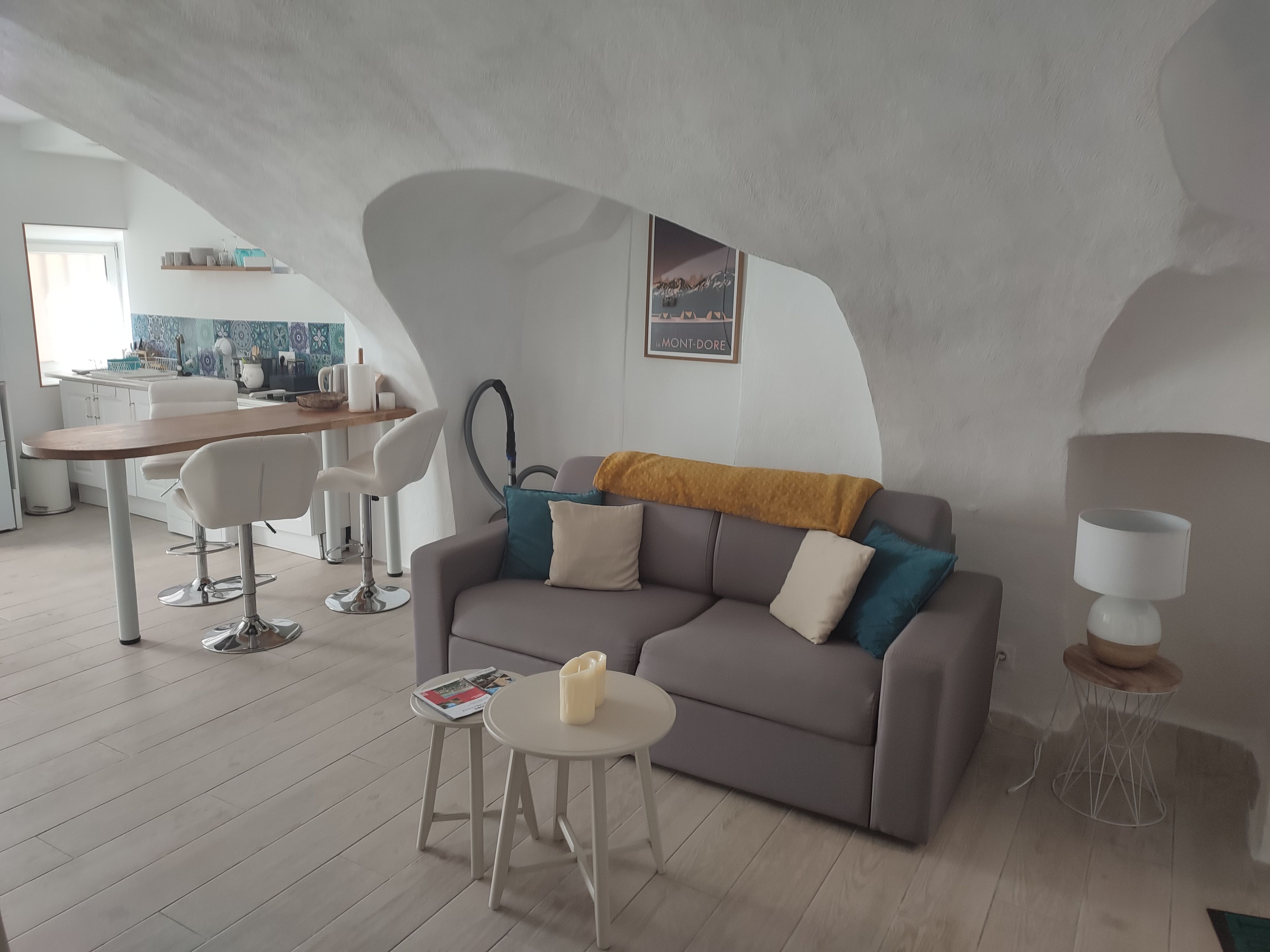 Een moderne woonruimte met een bank, salontafel en een eethoek met stoelen en een tafel.