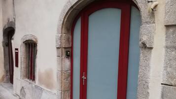 A building with a red door and a small window.