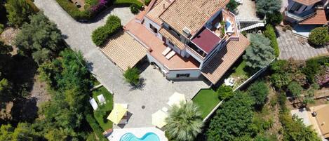 A residential property with a swimming pool, a covered patio, and a garden.