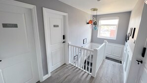 A hallway with two white doors, one labeled "Room 2" and the other "Room 1". - United Home B&B (Manchester)