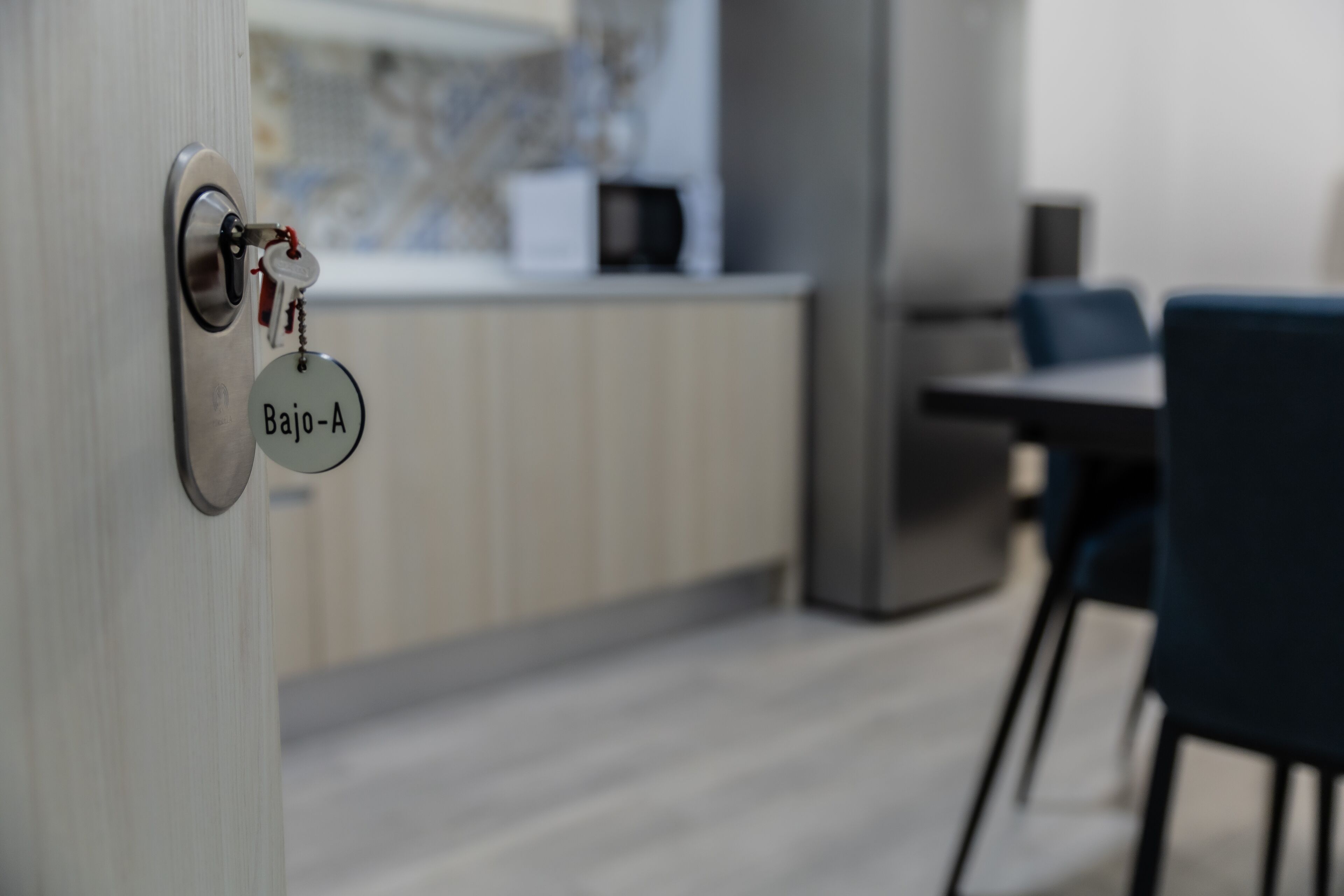 Una cocina moderna con encimera de madera, microondas y comedor con sillas.