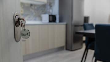 Una cocina moderna con encimera de madera, microondas y comedor con sillas.