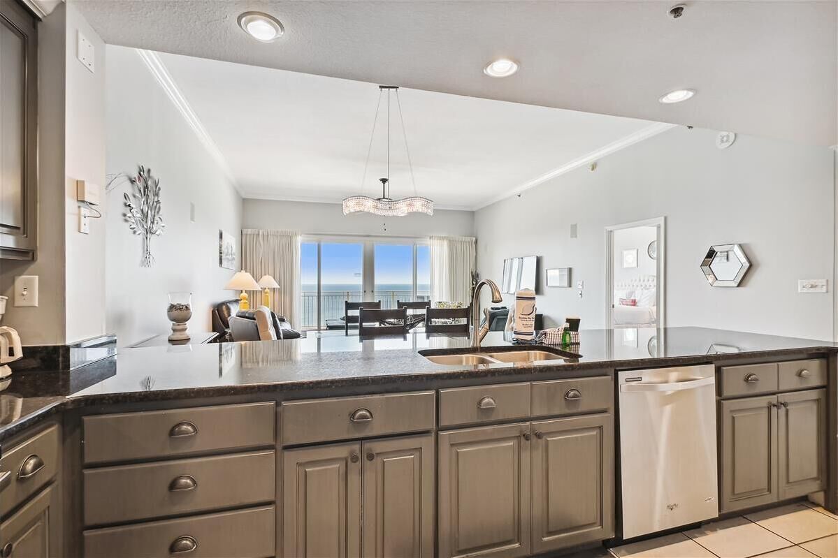 A modern kitchen with a large island, built-in appliances, and a view to the outside.