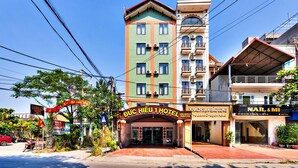 Un hotel con una entrada destacada, varios balcones y un cartel que indica que es el Jade Dragon Hotel.
