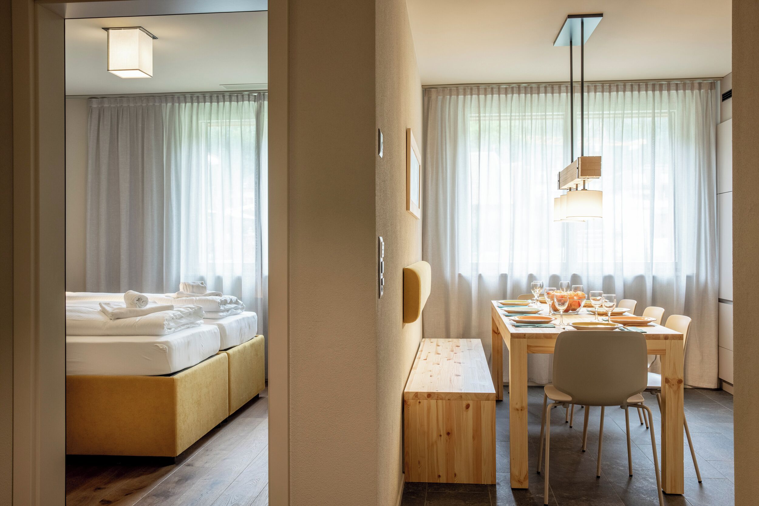 Una habitación de hotel con una cama, una mesa de comedor y un banco.