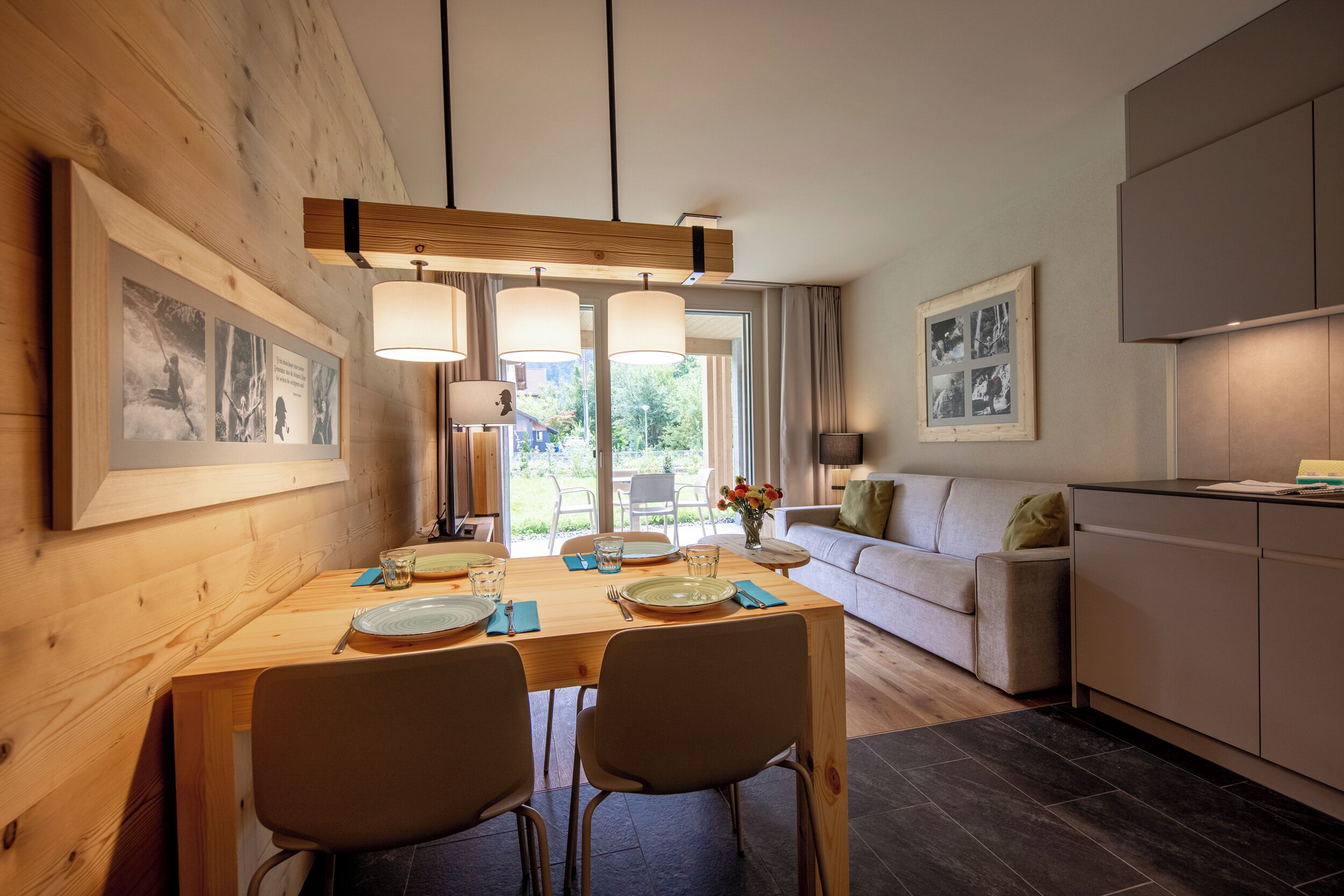 Een moderne eetruimte met een houten tafel, stoelen en hanglampen.