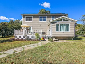 Stroll up to the charming entrance, flanked by windows, and step into a serene haven surrounded by mature trees and a beautifully manicured yard.