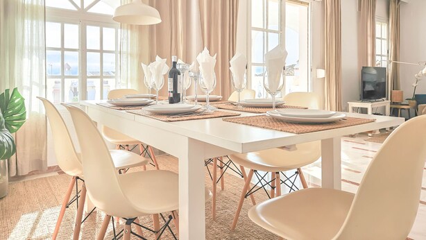A dining area with a white table set for four, including wine glasses and napkins. - Penthouse Apt, La Cala de Mijas Close to the Beach (Mijas Costa)