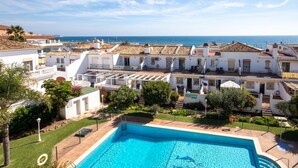 A residential area with a swimming pool, white buildings, and a view of the sea. - Penthouse Apt, La Cala de Mijas Close to the Beach (Mijas Costa)