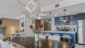 Una cocina moderna con armarios azules, un refrigerador de acero inoxidable y un microondas integrado.