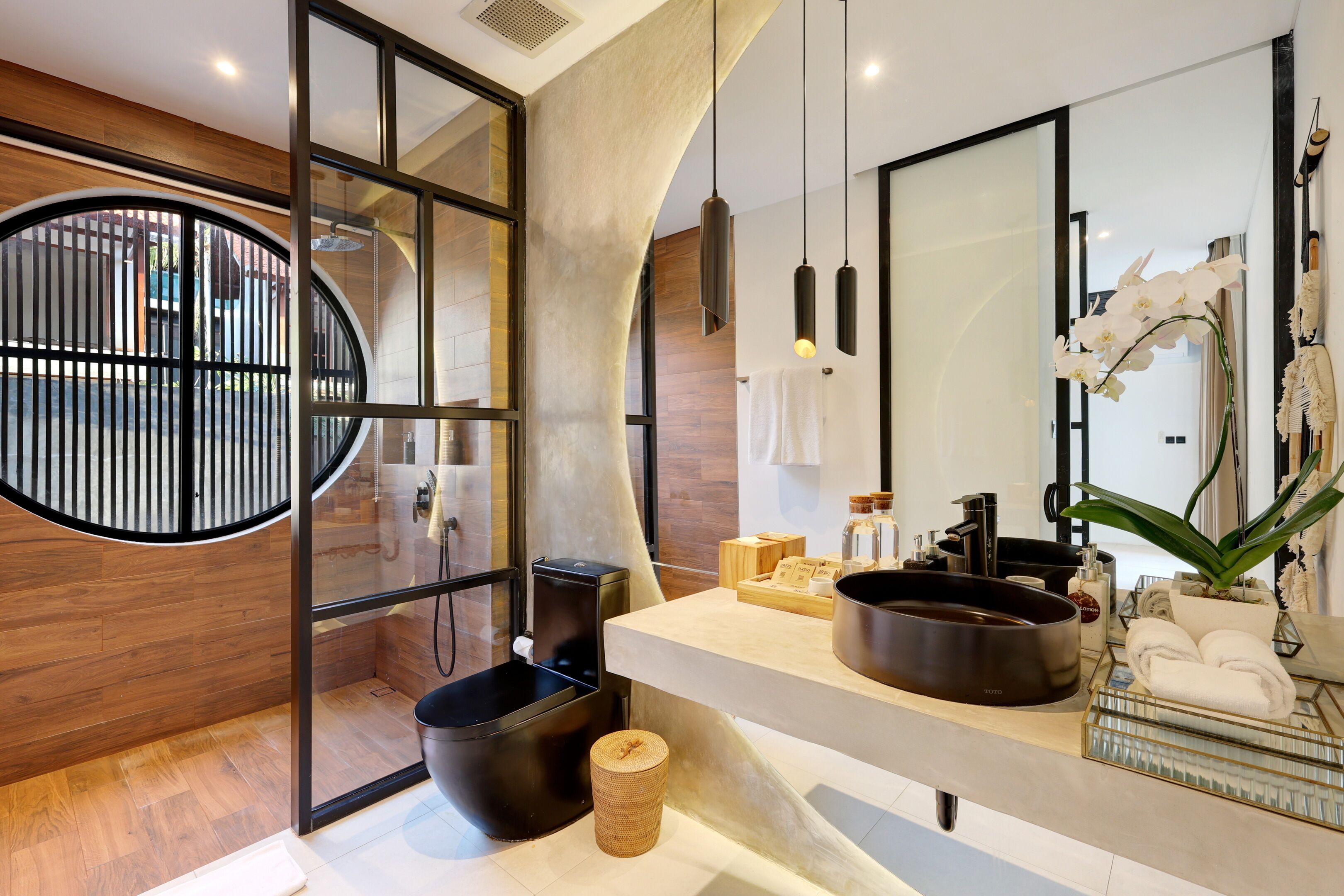 Un bagno moderno con un lavandino curvo, uno specchio grande e una parete decorata in legno.