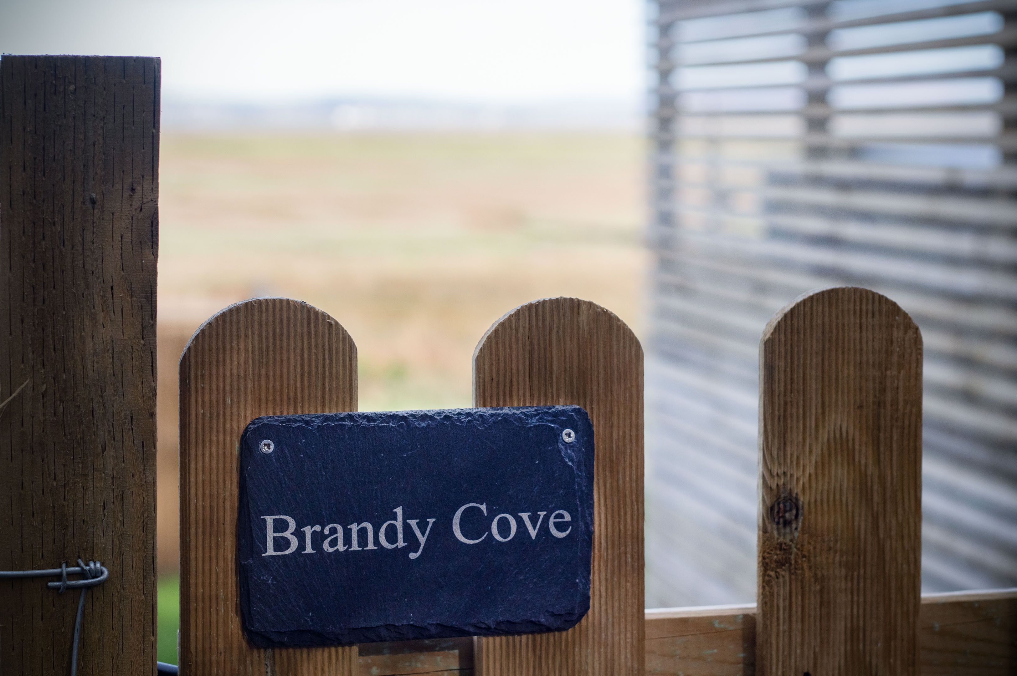 A wooden fence with a sign that reads "Brandy Cove."