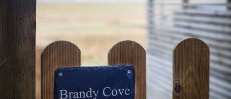 A wooden fence with a sign that reads "Brandy Cove."