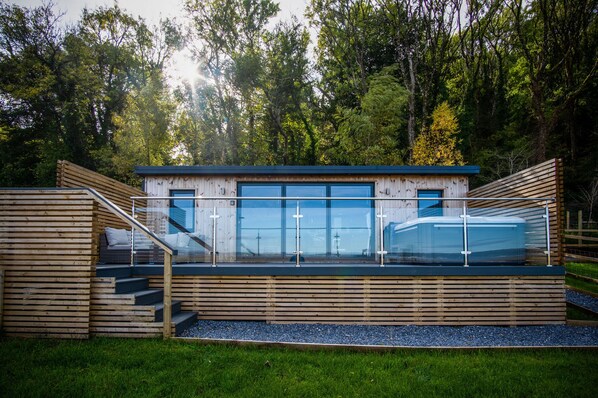 A modern wooden structure with a glass enclosure, wooden stairs, and a small pool. - Brandy Cove - 1 Bed Cabin - Landimore (Swansea)