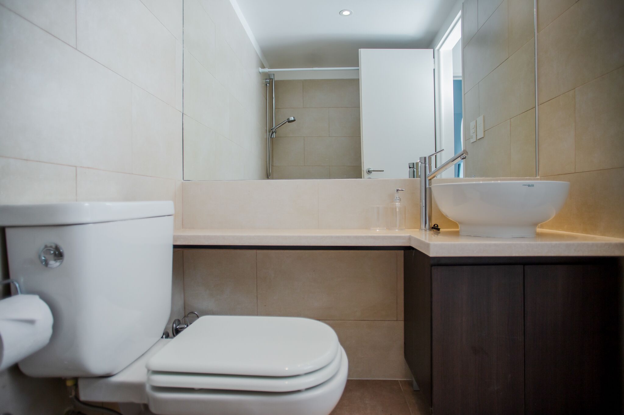 Un baño con inodoro, lavamanos y ducha.