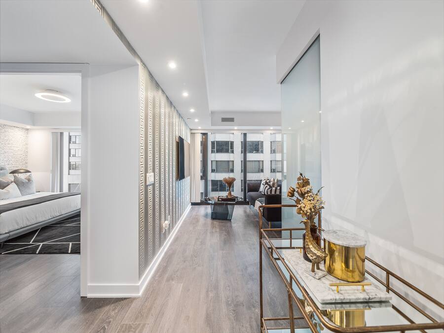 Une chambre d’hôtel moderne avec un lit, un bureau agrémenté d’un vase et une vue sur la ville.