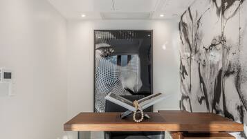 A modern office space with a wooden desk, a black office chair, and a glass partition.