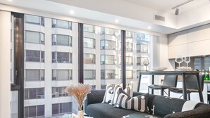 Una sala de estar moderna con un sofá, una mesa de centro de vidrio y un comedor con mesa y sillas.