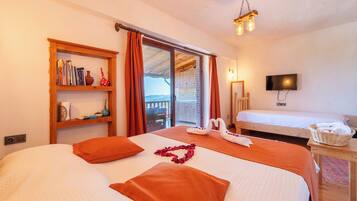 Una habitación de hotel con dos camas, una estantería, un televisor y un balcón con vistas.