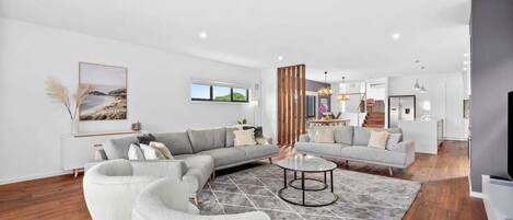 A spacious living area with a sofa set, a coffee table, and a rug.