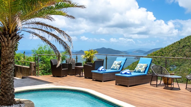 A poolside area with lounge chairs and a view of the ocean and mountains. - Mount Healthy Villas 1 Property -2 villas  6- bedrooms with spa & pool (Tortola)
